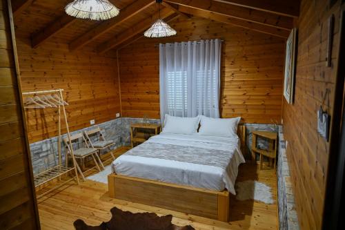 a bedroom with a bed in a wooden cabin at Airport Comfort Nest in Kamëz