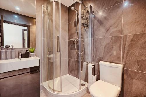 a bathroom with a shower with a toilet and a sink at 2 Bed 2 Bath Penthouse in Chelmsford City Centre with Free Parking ideal for long stays and Contractors - sleeps 6 in Chelmsford