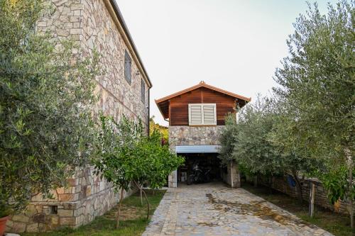 a stone building with a gate and a house at Airport Comfort Nest in Kamëz