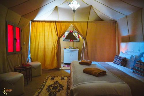 a room with a large bed in a tent at Dounia Luxury Camp in Merzouga