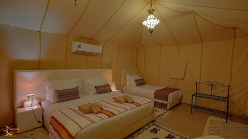 a bedroom with two beds in a tent at Dounia Luxury Camp in Merzouga