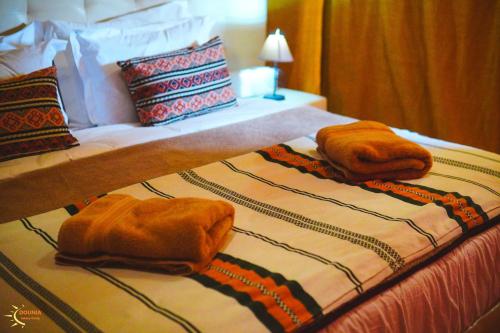 two towels are on top of a bed at Dounia Luxury Camp in Merzouga