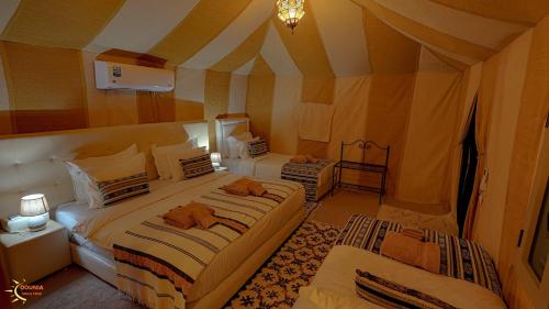 a bedroom with two beds in a tent at Dounia Luxury Camp in Merzouga