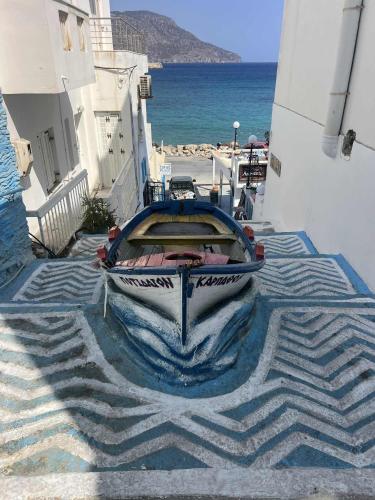 a boat sitting on the ground next to the ocean at Dolphin Hotel Apartments in Karpathos Town