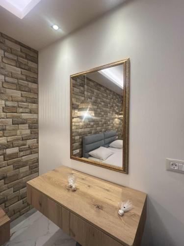 a mirror on a wall with a bed in a room at Dolphin Hotel Apartments in Karpathos Town