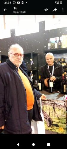 an older man standing at a counter in a wine store at B&B La Veronica in Pianillo