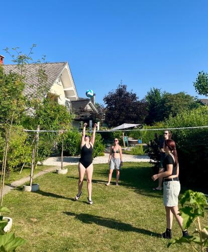 a group of people playing volleyball in a yard at Garden Paradise Bled Apartments - garden, pond and castle view in Bled