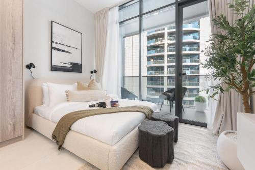 a bedroom with a bed and a large window at Free housekeeping visits during your stay - StayShort - Sports City Studio sleeps 2 with Swimming Pool in Dubai