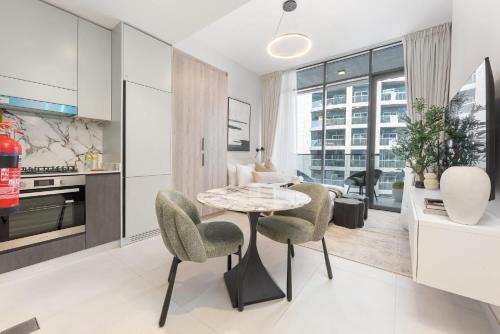 a kitchen and living room with a table and chairs at Free housekeeping visits during your stay - StayShort - Sports City Studio sleeps 2 with Swimming Pool in Dubai