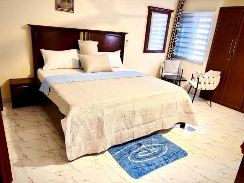クマシにあるFloswick Hotelのベッドルーム1室(大型ベッド1台、青い掛け布団付)