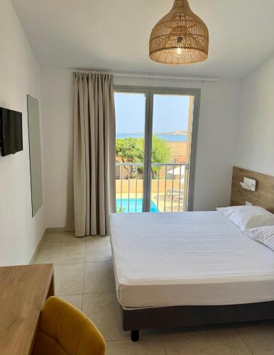 a bedroom with a bed and a view of the ocean at Hotel L'ondine in Algajola