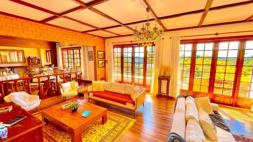 a living room with a couch and a table at Pousada Hortelã Village in Campos do Jordão