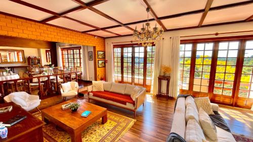 a living room with a couch and a table at Pousada Hortelã Village in Campos do Jordão