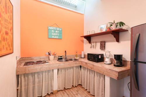 a kitchen with a counter with a sink and a refrigerator at Kalawala in Puerto Viejo