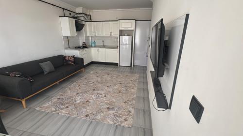 een woonkamer met een bank en een koelkast bij Köşk Rezidans 