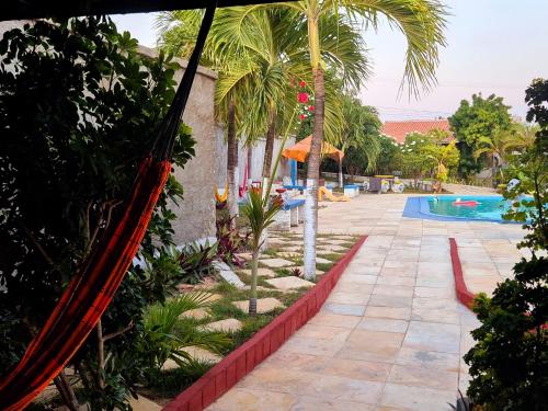 a resort with a hammock by a swimming pool at Flat da Claudia canoaQUEBRADA in Canoa Quebrada