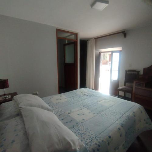 a large bed in a bedroom with a window at Casona Buenavista Andahuaylillas in Andalmailillas