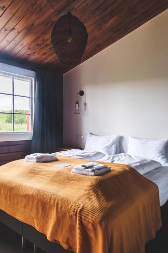 a bedroom with a bed with two towels on it at Hótel Goðafoss Fosshóll in Godafoss