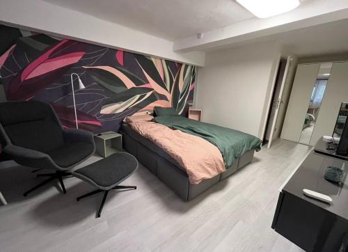 a bedroom with a bed and a chair and a painting at E11 Cologne in Cologne