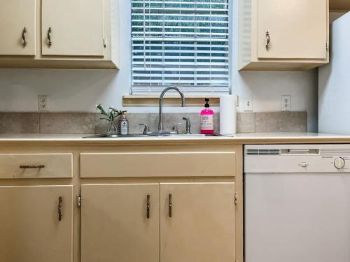 a kitchen with white cabinets and a sink and a window at The Budget Friendly Home in Perkins