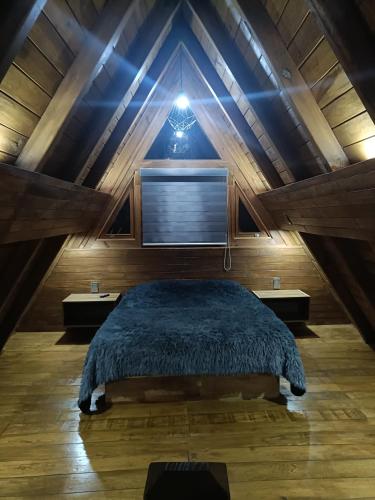 a bedroom with a large bed in a attic at Cabañas el tigre in Mazamitla