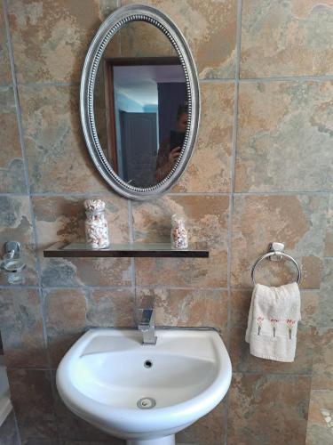 a bathroom with a sink and a mirror on a wall at 23 On Beach in Stompneusbaai