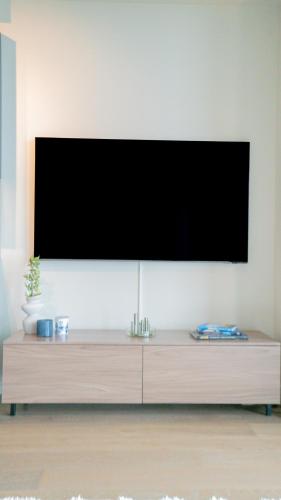 a flat screen tv on top of a wooden entertainment center at Karlatornet Sky Level in Gothenburg