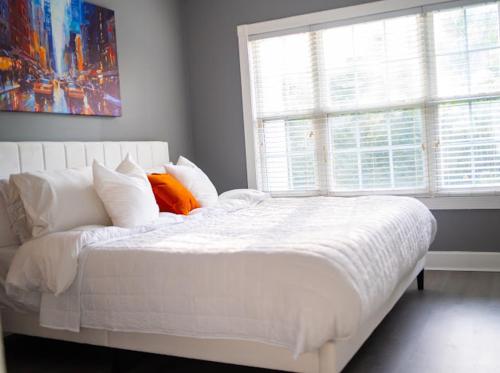 a white bed with pillows and a window in a bedroom at The Blue Oasis in Charlotte