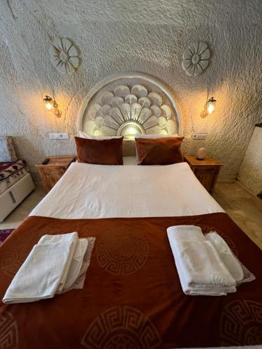 a bedroom with a large bed with two towels on it at Tatlı Kaya Otel in Urgup
