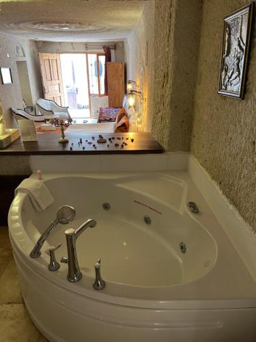 a white bath tub in a bathroom with a counter at Tatlı Kaya Otel in Urgup