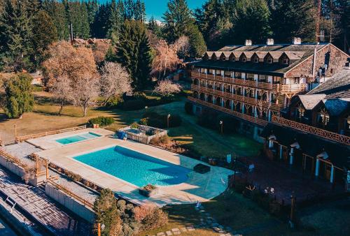 einen Luftblick auf ein großes Haus mit einem Pool in der Unterkunft Navidad mágica en Manzano Resort Cabaña completa para 8 personas in Villa La Angostura