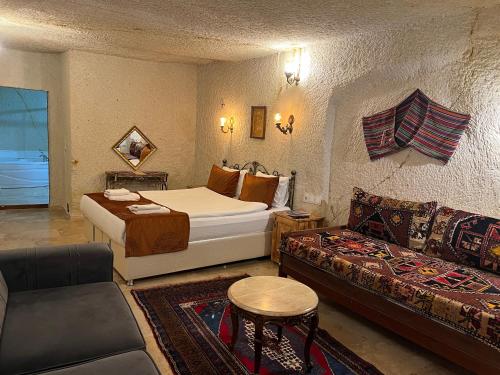 a hotel room with a bed and a couch at Tatlı Kaya Otel in Urgup