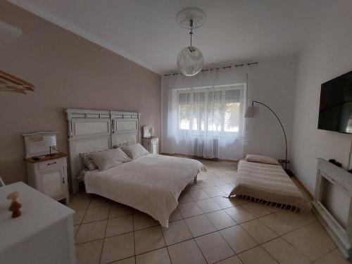 ein weißes Schlafzimmer mit einem Bett und einem Fenster in der Unterkunft La Finestra sulla Storia in Asti