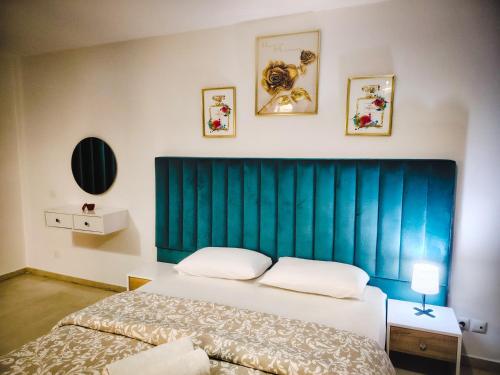 a bedroom with a large bed with a blue headboard at Perfect Appartement a Malabata au plein centre ville en face Hilton & la Gare de Train TGV N3 in Tangier