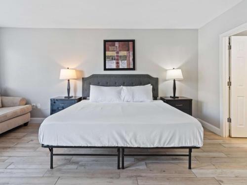 a bedroom with a large white bed with two lamps at JS Luxury Vacation in Orlando