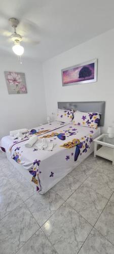 a bedroom with a bed with a floral bedspread at IRIS HOME POOL and GARDEN in Benalmádena