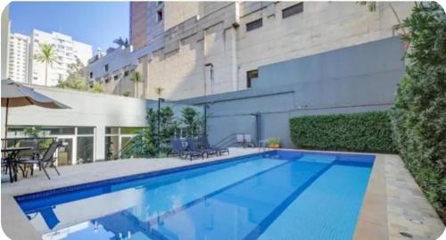 a swimming pool in front of a building at Flat Wyndham2 Paulista com estacionamento in Sao Paulo
