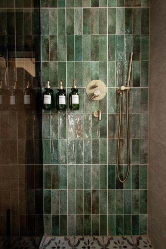 a green tiled shower with four bottles of wine at Dzvin in Slavske