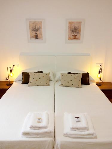 a large white bed with two folded towels on it at Hoya del Agua Casa Rural in Casas de Haro