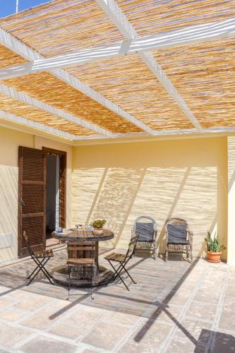 a patio with a table and chairs and a wooden ceiling at Attico con vista, Wi-Fi, Netflix, Amazon Prime e parcheggio in Lecce