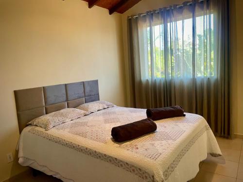 a bed in a bedroom with a large window at Casa Bela Vista - Penedo in Penedo