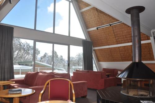a living room with red furniture and large windows at Ripparoo Lodge in Falls Creek