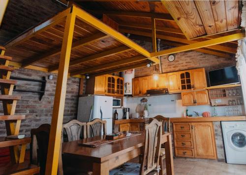 a kitchen with wooden cabinets and a table with chairs at Loft PetFriendly en Maipú cerca de Bodegas y Viñedos, con Jardín y Cochera in Maipú