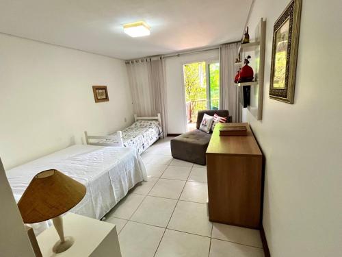 a bedroom with two beds and a couch and a window at Casa de Praia em Carneiros in Tamandaré
