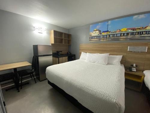 a hotel room with a bed and a desk and a bed sidx sidx sidx sidx at Days Inn & Suites by Wyndham Texas City in Texas City