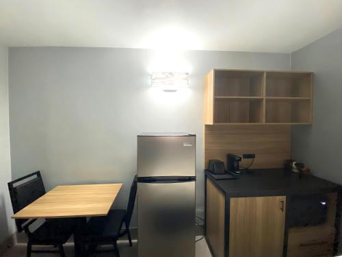a kitchen with a stainless steel refrigerator and a table at Days Inn & Suites by Wyndham Texas City in Texas City