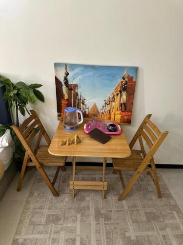 a wooden table with two chairs and a painting on the wall at king pyramids in Cairo