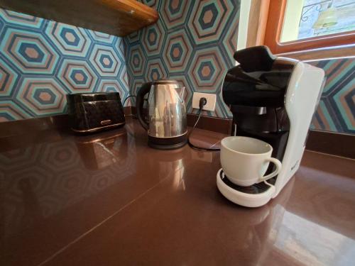 a counter with a coffee maker and a cup on it at Casa BuenaOnda Asunción in Asuncion
