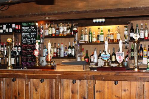 a bar with a lot of bottles of alcohol at Sibton White Horse Inn in Saxmundham