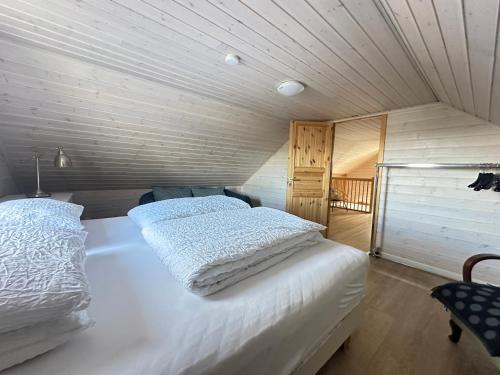 a white bed in a room with a wooden ceiling at Holiday Home in town Eyrarbakki South of Iceland - Birta Rentals in Eyrarbakki